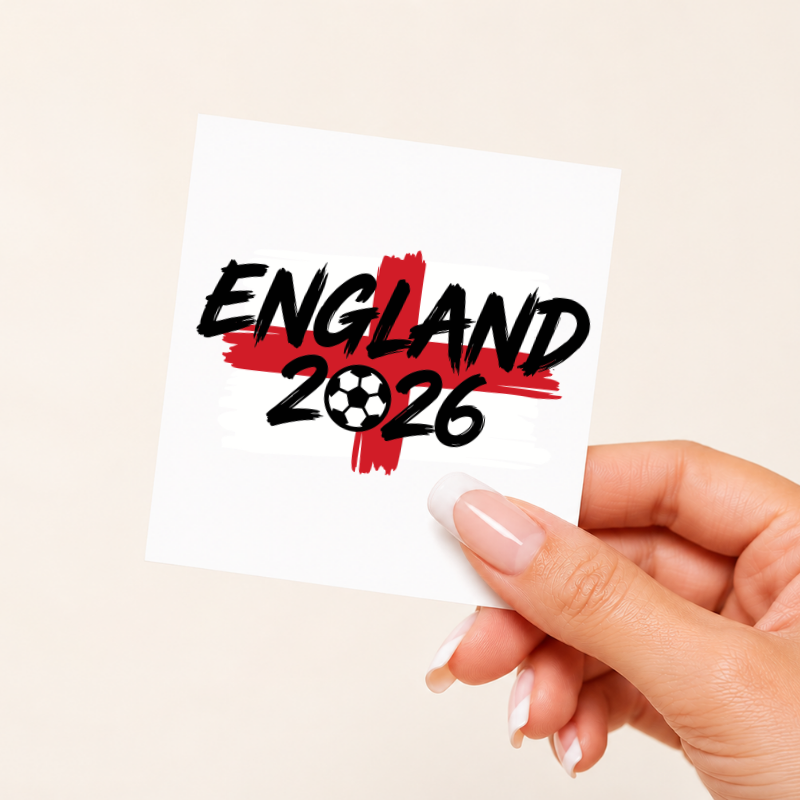 Hand holding a card with 'England 2026' text on a beige background