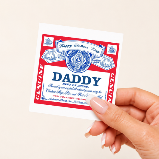 Hand holding a 'Daddy' beer label with red and blue design on a beige background