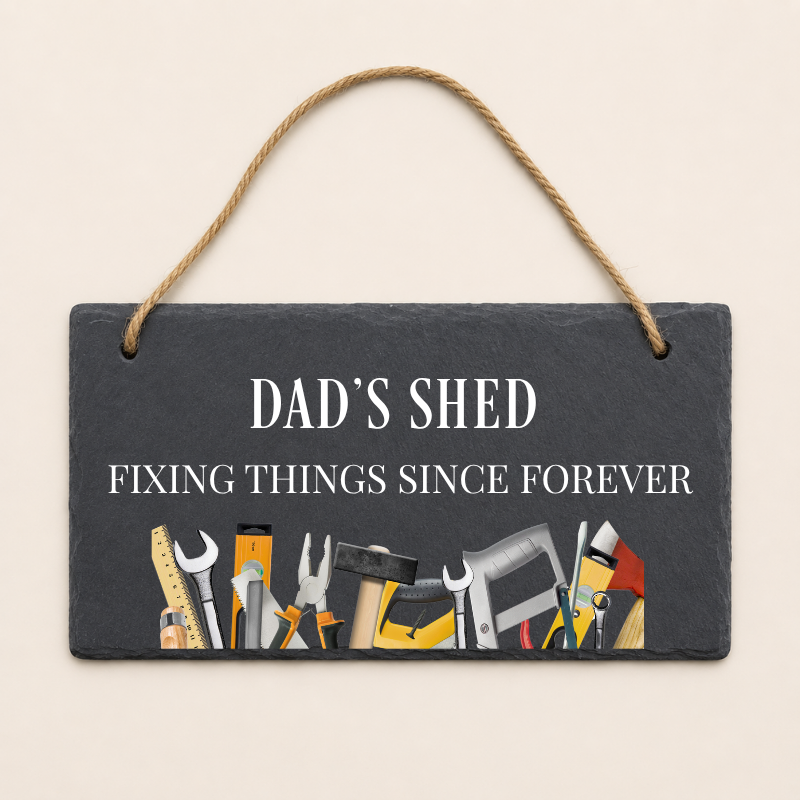 Slate sign with tools illustration and 'Dad's Shed' text on a beige background