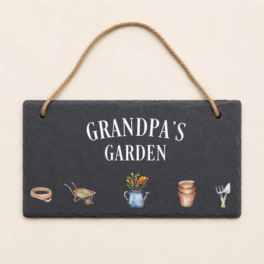 Slate sign with 'Grandpa's Garden' text and gardening illustrations on a beige background